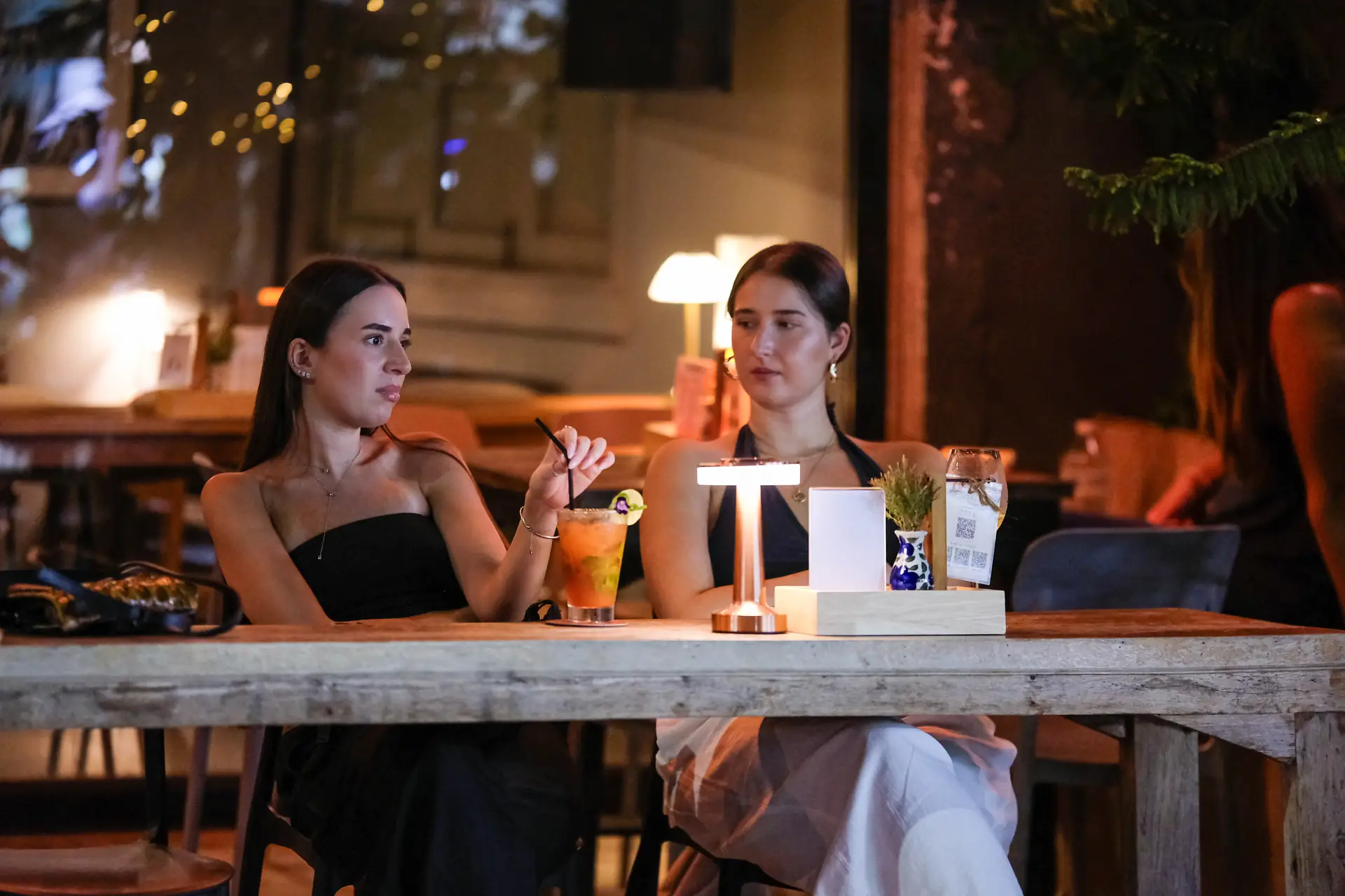 Two guests with a cocktail at a front table of Vermut Café, Pai Walking Street