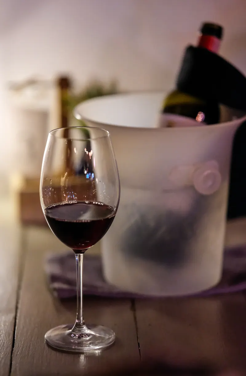 A glass of red wine beside the ice bucket at Vermut Café