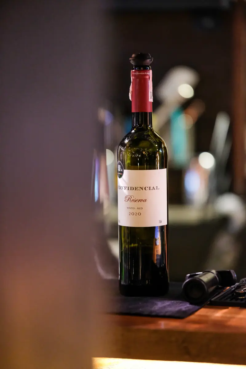 A single bottle on the counter under a warm lamp · Vermut Café, Pai Walking Street