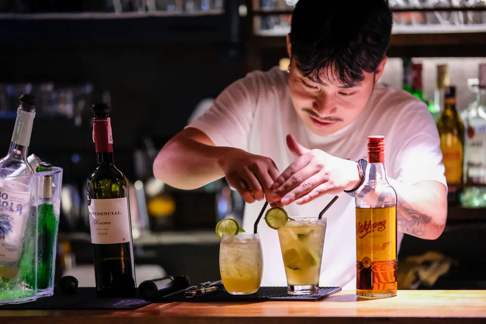 Two fresh drinks with lime, the garnish going on · Vermut Café, Pai Walking Street