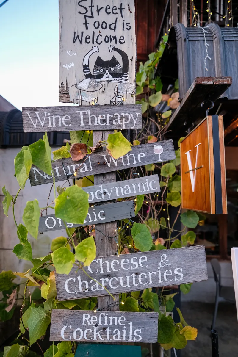 The signpost out front — Street food is welcome, wine, cheese and charcuterie, cocktails · Vermut Café, רחוב ההליכה בפאי
