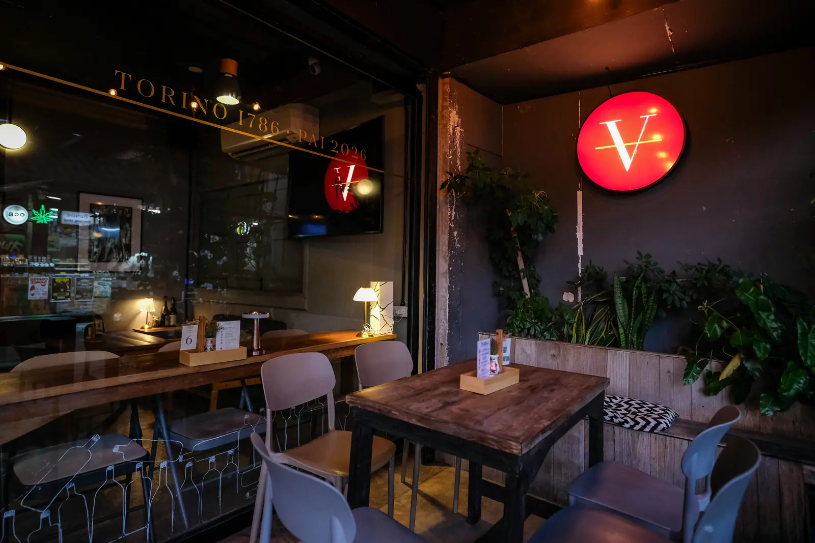 The side terrace tables under the red V, seen from inside · Vermut Café, Pai Walking Street