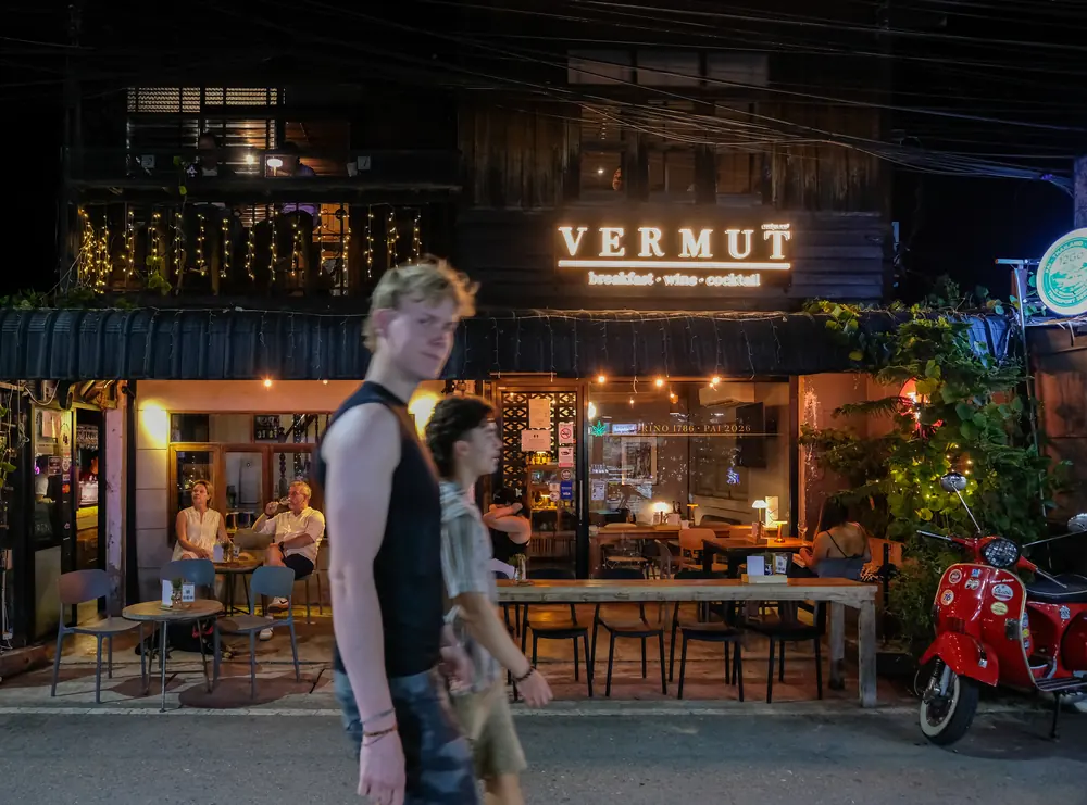The lit VERMUT sign at night, a couple walking past the open front · Vermut Café, Pai Walking Street