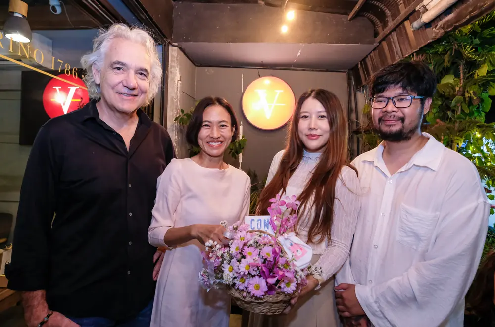 Friends with flowers at the door under the red V · Vermut Café, Pai Walking Street