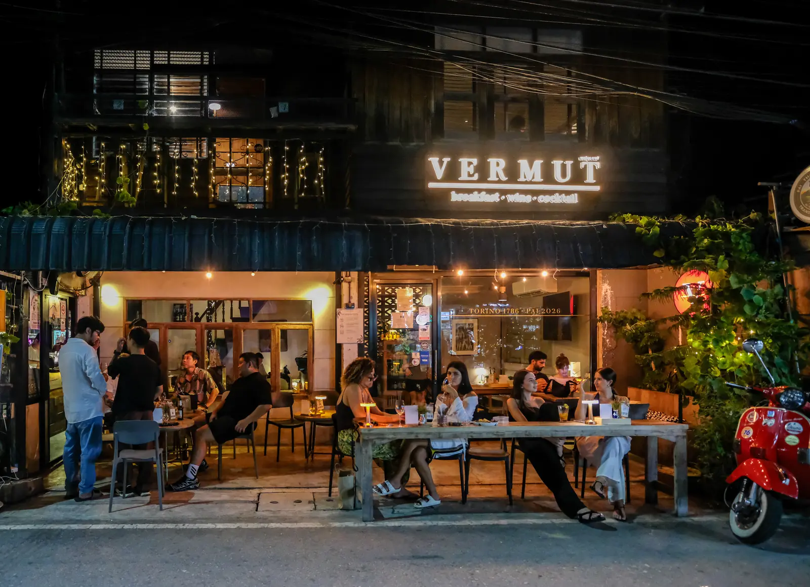 Vermut Café shopfront at night on Pai Walking Street, guests at the tables outside