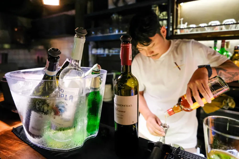 Pouring at the counter, the ice bucket beside · Vermut Café, רחוב ההליכה בפאי