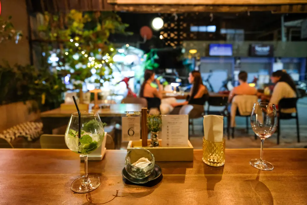 Cocktails on the counter, the terrace and street behind · Vermut Café, רחוב ההליכה בפאי